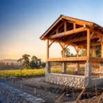 Partially completed timber frame on a stone foundation, representing a second stage ESOP transaction to full ownership
